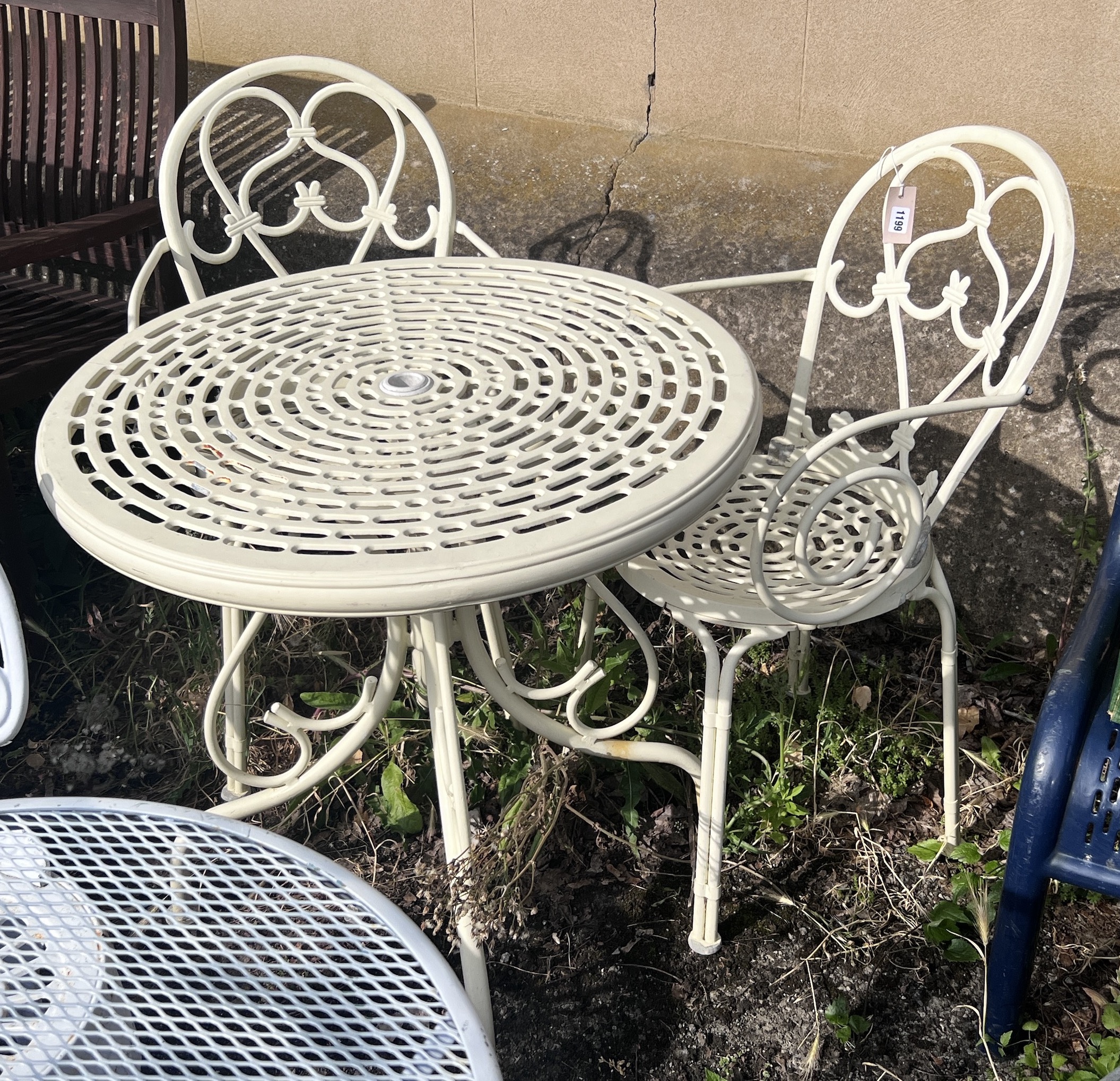 A circular aluminium garden table, diameter 74cm, height 73cm, and two elbow chairs